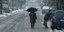 Γυναίκα περπατά με ομπρέλα στο χιόνι