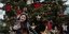 Κοπέλα ποζάρει μπροστά από δέντρο Χριστουγέννων