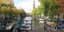 Νεαρή γυναίκα περνά με ποδήλατο από γέφυρα καναλιού του Αμστερνταμ