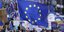 Διαδηλωτές κρατούν μια μεγάλη σημαία της Ευρωπαϊκής Ένωσης