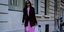 γυναίκα με ροζ φόρεμα και σακάκι περπατά στην εβδομάδα μόδας