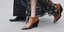 γυναίκα με ankle boots και φούστα περπατά στο δρόμο