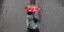Γυναίκα περπατά σε δρόμο του Σίδνεϊ της Αυστραλίας κρατώντας ομπρέλα για τον βροχερό καιρό