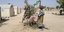 Γυναίκα απλώνει τα ρούχα της σε δέντρο σε καταυλισμό της Μπουρκίνα Φάσο