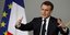 Ο Εμανουέλ Μακρόν με ανοικτά τα χέρια μιλά μπροστά από σημαίες της Γαλλίας και της ΕΕ