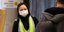Γυναίκα με γιλέκο εργασίας και ιατρική μάσκα