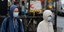 Ανδρες με ιατρικές μάσκες και κουκούλα έξω από μετρό στην Αγγλία