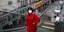 Γυναίκα με κόκκινο μπουφάν και μάσκα ανεβαίνει σκαλιά