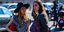 Γυναίκες με σακάκι και καπέλο συζητούν στην εβδομάδα μόδας