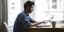 Τηλεκπαίδευση: Ενας άνδρας κάθεται μπροστά στο laptop του