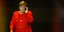 Η καγκελάριος Ανγκελα Μέρκελ με κόκκινο σακάκι, μιλά στο κινητό τηλέφωνο