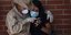 Ζευγάρι στη Βενεζουέλα με μάσκες κοιτάζει στο κινητό