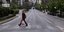 Γυναίκα περπατά σε άδειο δρόμο της Αθήνας