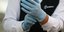 Άνδρας φορά προστατευτικά γάντια ενάντια στον κορωνοϊό