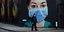 Ανδρας με μάσκα για τον κορωνοϊό στην Βρετανία μπροστά από γκράφιτι νοσοκομας