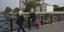 Γάλλοι πολίτες με μάσκες σε γέφυρα του Σηκουάνα, με φόντο την Παναγία των Παρισίων