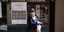 Γυναίκα με μάσκα έξω από κλειστό κατάστημα στη Γαλλία, εξαιτίας των μέτρων περιορισμού για τον κορωνοϊό