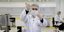 Άνδρας σε εργαστήριο με μάσκα, γάντια και στολή για τον κορωνοϊό