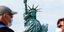 Ζευγάρι με μάσκες για τον κορωνοϊό μπροστά από το Αγαλμα της Ελευθερίας στη Νέα Υόρκη