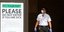 Αστυνομικός με μάσκα στις ΗΠΑ δίπλα από πινακίδα για τον κορωνοϊό