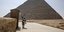 εργαζόμενος ψεκάζει σε αρχαιολογικό χώρο με πυραμίδες στην Αίγυπτο