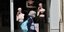 Γυναίκα με μάσκα προστασίας από τον κορωνοϊό μπροστά από βιτρίνα με πλαστικές κούκλες στο Παρίσι