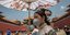 Κινέζες στην απαγορευμένη πόλη με μάσκα για κορωνοϊό και ομπρέλα