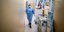 Νοσηλεύτρια περπατά σε διάδρομο νοσοκομείου