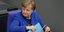 Η Γερμανίδα Καγκελάριος Ανγκελα Μέρκελ με σφιγμένα χείλη και μπλε σακάκι