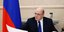 Ο Ρώσος πρωθυπουργός Μικαίλ Μισούστιν στο γραφείο του μελετά έγγραφα με φόντο τη ρωσική σημαία