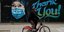 Ποδηλάτης περνά μπροστά από γκράφιτι με μάσκα στην Βρετανία