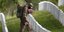 Στρατιώτης με μάσκα για τον κορωνοϊό, αφήνει αμερικανικές σημαίες σε τάφους