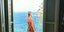 Η Τζένη Μπαλατσινού στο μπαλκόνι σπιτιού με θέα τη θάλασσα