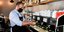επίδομα 800 ευρώ : εργαζόμενος ετοιμάζει καφέ σε καφετέρια φορώντας μάσκα