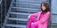 Η Αλεξάνδρα Παλαιολόγου με ροζ ρούχα καθισμένη σε σκάλες