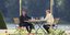Ο Εμανουέλ Μακρόν με την Ανγκελα Μέρκελ σε τραπέζι κήπου