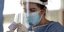 Γιατρός με μάσκα και ασπίδα προσώπου παίρνει δείγμα για έλεγχο