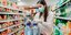 Κορωνοϊός: Μια γυναίκα ψωνίζει σε σούπερ μάρκετ φορώντας μάσκα