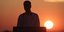 Ο Κυριάκος Μητσοτάκης με φόντο το ηλιοβασίλεμα της Σαντορίνης