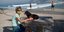 Γυναίκα με το σκυλί της στην παραλία, φορώντας μάσκα για τον κορωνοϊό
