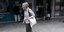 Αναδρομικά: Μια ηλικιωμένη γυναίκα περνά μπροστά από ΑΤΜ τράπεζας