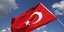 Η τουρκική σημαία κυματίζει με φόντο συννεφιασμένο ουρανό