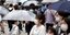 Ιάπωνες με μάσκες και ομπρέλες στον δρόμο