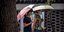 Γυναίκες στη Κίνα με ομπρέλες και μάσκες για τον κορωνοϊό