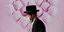 Ραβίνος περπατά δίπλα σε τοιχογραφία με ροζ μπαλόνια, φορώντας μάσκα για τον κορωνοϊό