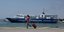Γυναίκα με βαλίτσα τρέχει στην προκυμαία στο λιμάνι του Πειραιά