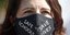 Γυναίκα φορά μάσκα ενάντια στον κορωνοϊό με το μήνυμα «ασφαλή σχολεία σώζουν ζωές»