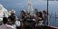 Τουρίστες στη Σαντορίνη με θέα το γαλάζιο του Αιγαίου
