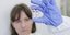 γυναίκα κρατά φιαλίδια με εμβόλιο για κορωνοϊό
