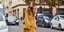 Γυναίκα με κίτρινο, μακρυμάνικο φόρεμα στο δρόμο 